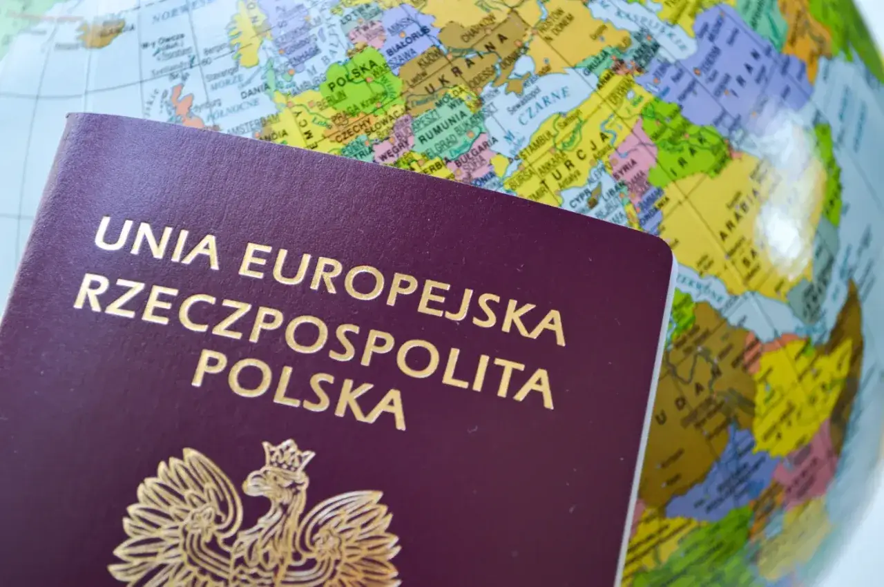 Polski paszport na tle globusa. Zastanawiasz się, ile kosztuje wyrobienie paszportu?